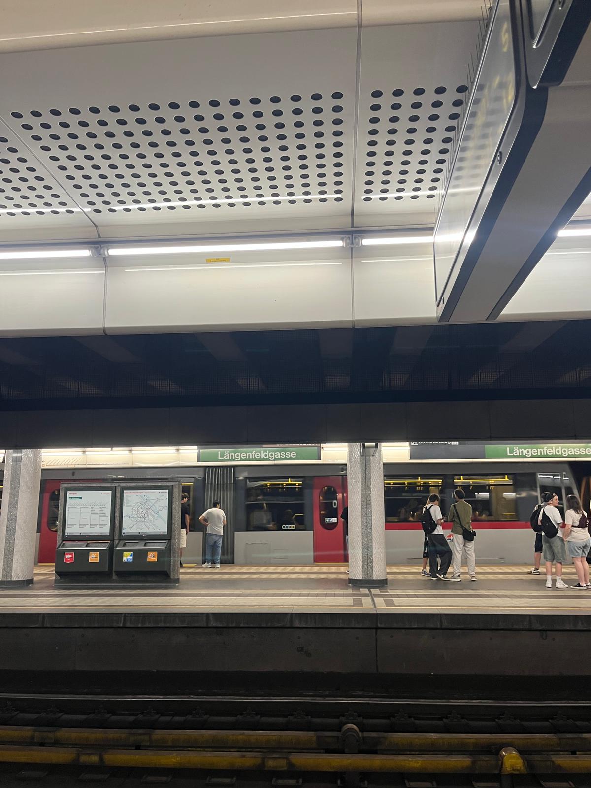 An empty metro platform with a train waiting at the doors